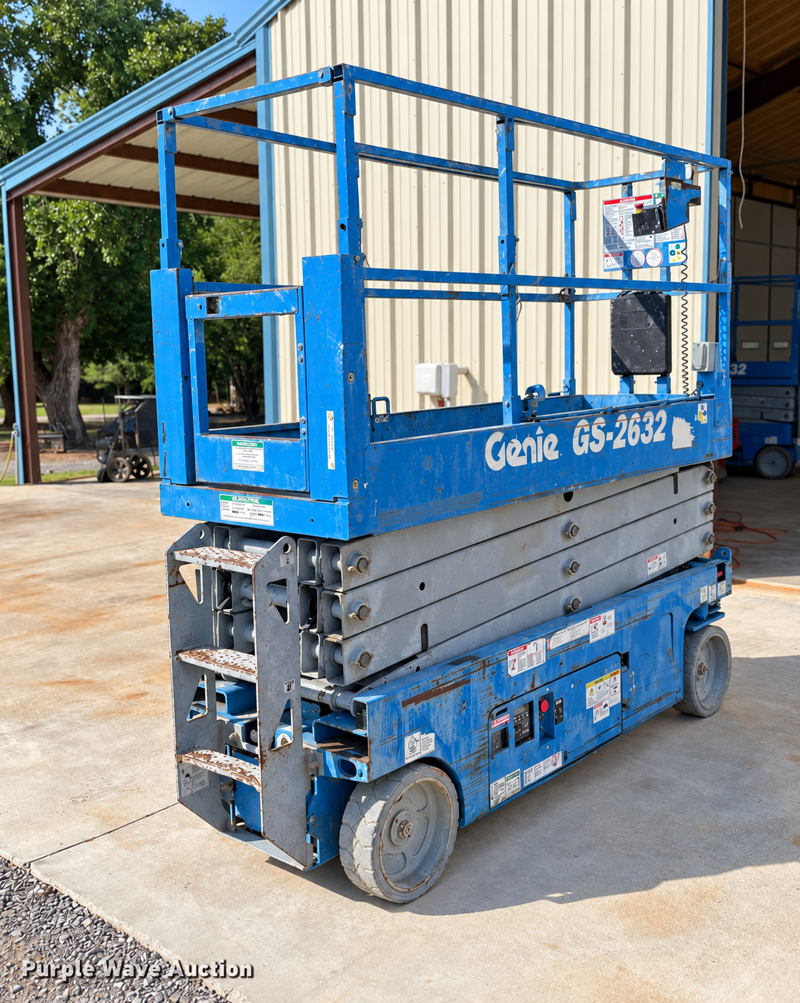 Blue Genie GS-2632 26-foot scissor lift outside a workshop, photo enhanced for clarity